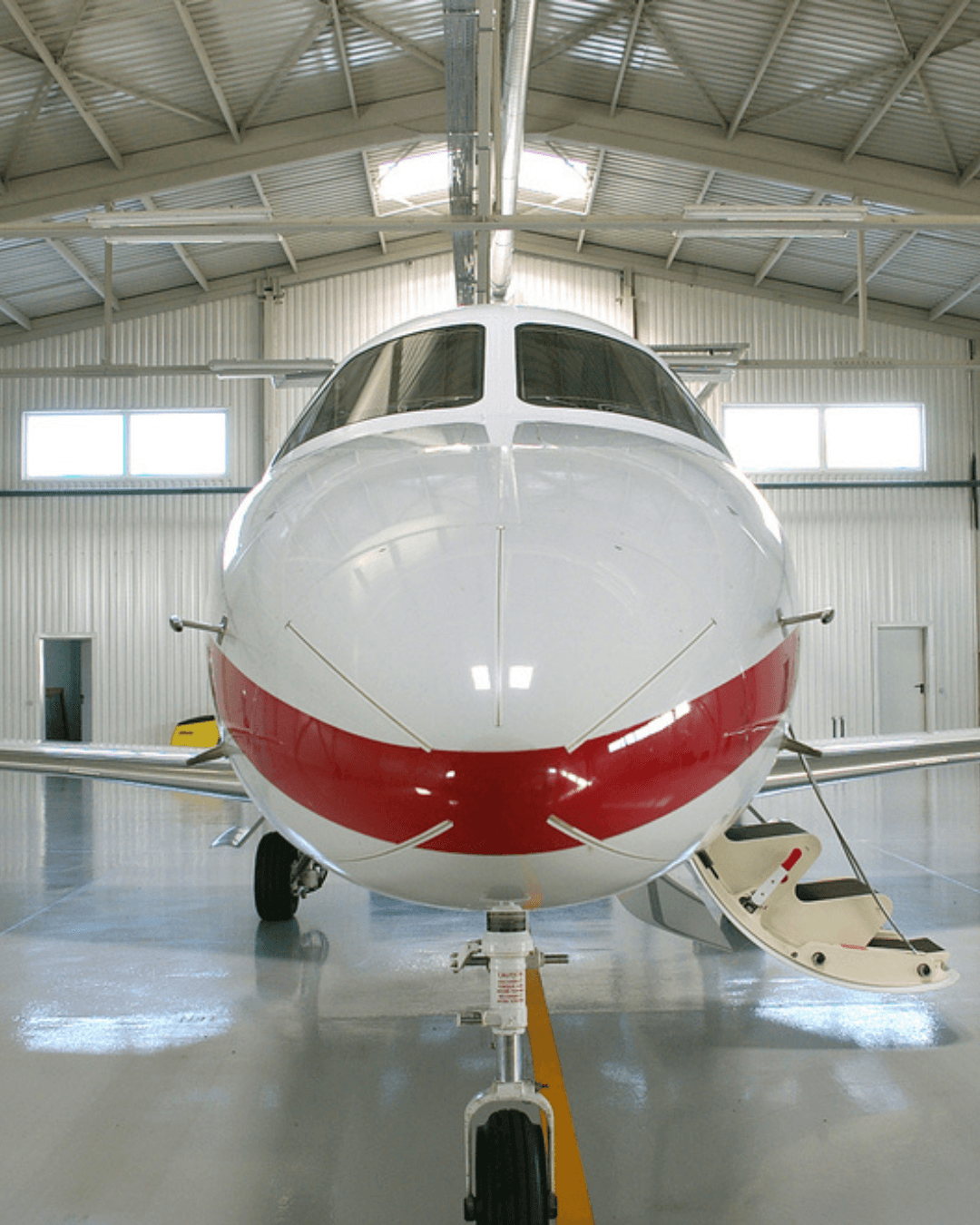 Hangar de aviación con jet privado sobre piso epóxico