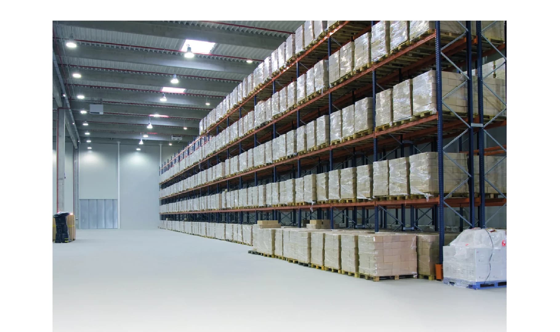 Almacén comercial con estanterías ordenadas y piso epóxico continuo Tecnofloor