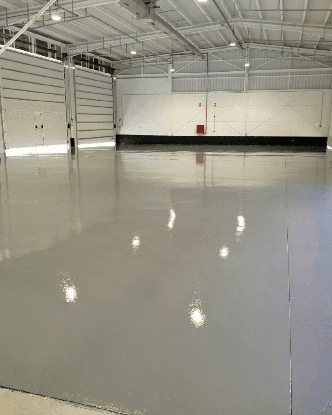 Nave industrial con piso epóxico Tecnofloor de alta resistencia y techos altos con luminarias